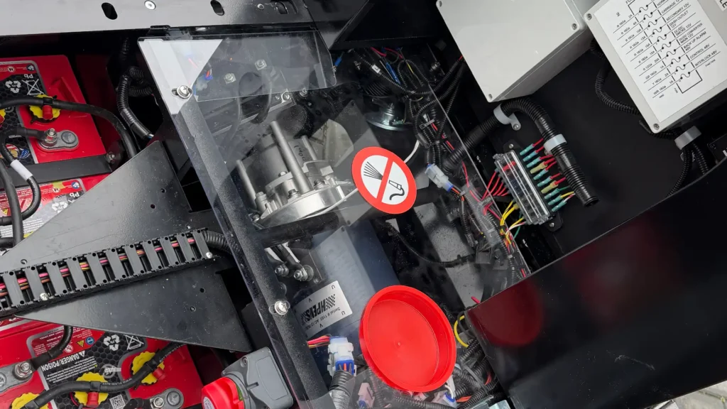 Interior view of Wattman electric trackless train drivetrain compartment showing certified electrical system, wiring, and safety components