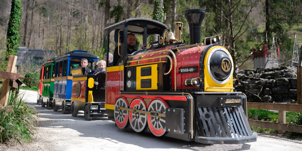 Wattman Mini Express electric trackless train SikyExpress carrying families on a woodland trail at Skypark